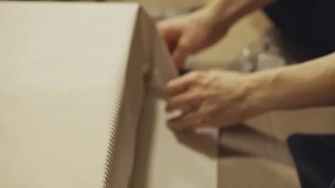 Hands Tape the Edge of the Wrapping Paper Securely in Place While Finishing a Stock Footage 332934632