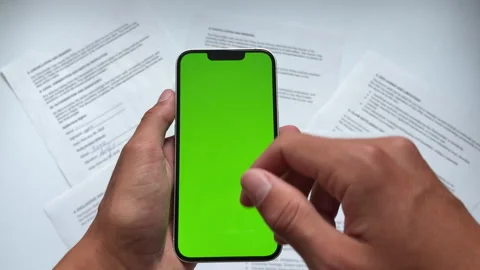 Hands tapping green screen smartphone managing corporate investment portfolio. Stock Footage 338188533
