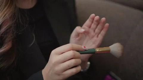 Hands tapping soft makeup brush on back of hand to test powder texture and Stock Footage 346631012