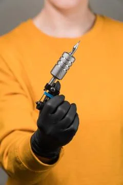 In the hands of a tattoo machine permanent Stock Photos