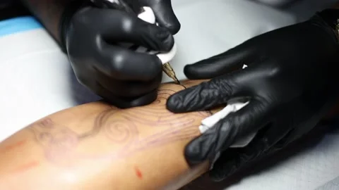 Hands of tattoo master closeup busy with work at tattoo shop. Stock Footage 179693148