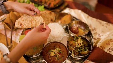 Hands Tearing Naan Bread Over Traditional Indian Thali Platter Video stock 337535075