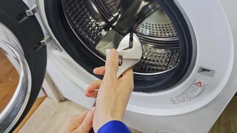 Hands of a technician adjusting the door latch of a washing machine Video stock 336480261