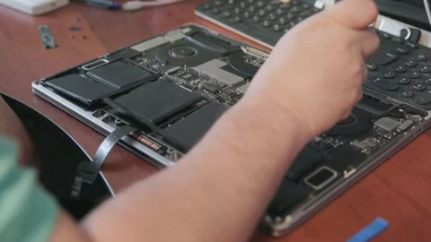 Hands of a technician dismantling a lithium-ion laptop battery using a special Stock Footage 335560498