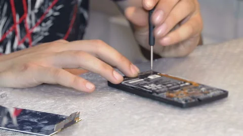 Hands of the technician screw with a screwdriver smartphone Stock Footage 63091633