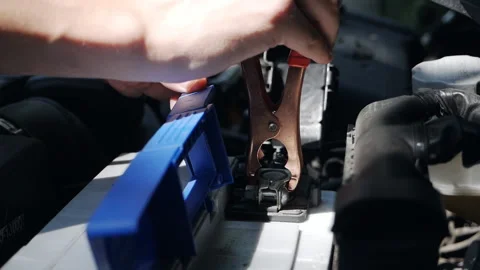The hands of technicians use charging cables for batteries for cars. The concept Stock Footage 160218250