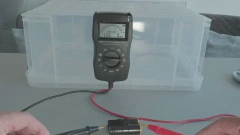 Hands test battery pack with a multimeter Stock Footage 340530727