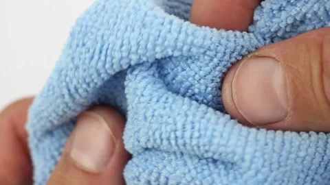 Hands testing blue microfiber dusting cloth Видео 160053115