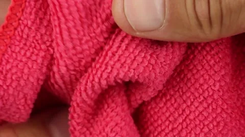 Hands testing, crushes and stretches red microfiber dusting cloth Video stock 160053187