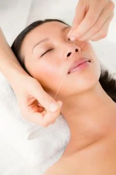 Hands threading beautiful womans face Stock Photos