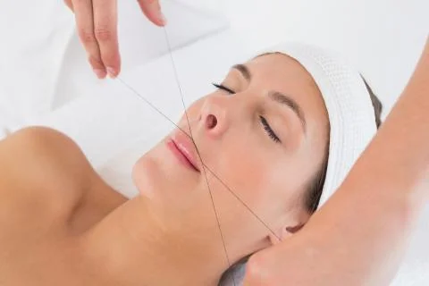 Hands threading beautiful woman's upper lip Stock Photos