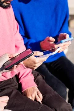 Hands of three young adults using mobile phones Stock Photos