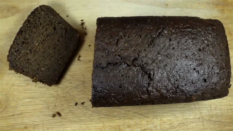 Hands throw pieces of brown bread on a loaf in slow motion. Stock Footage 133043622