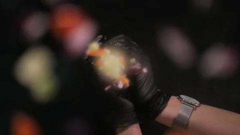 Hands throw pieces of vegetables down to the glass. Slow motion Stock Footage 108685697