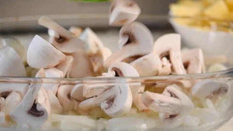 Hands throw off sliced champignons with a knife from cutting board into  bowl. Vidéo 127115342