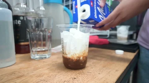 Hands throwing milk into a coffee cup Stock Footage 236452621