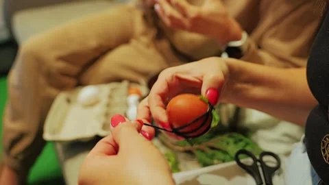 Hands Tie Thread Around Egg With Green Leaves For Natural Easter Egg Decorating Stock Footage 344008074