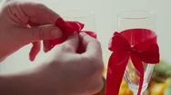 Hands Tied Red Bow On A Transparent Glass Of Champagne Stock Footage
