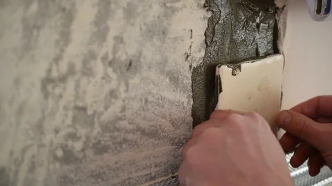 Hands of tile worker gluing square tiles to a wall Stock Footage 88390759