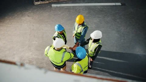 Hands together, support and engineer with above of people in building for Stock-Fotos