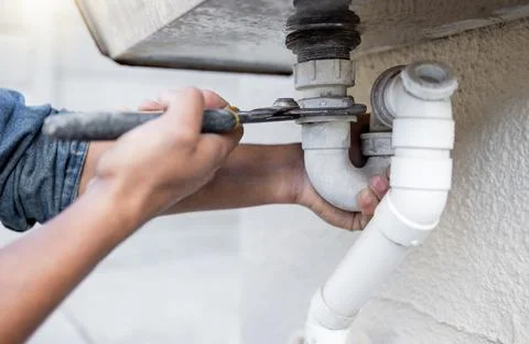 Hands, tool and pipe with a man plumber fixing a water system as a DIY handyman Stock Photos