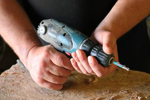 Hands with a tool on the background of a carpentry workshop. Stock Photos