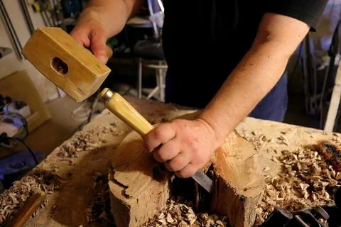 Hands with a tool on the background of a carpentry workshop. Stock Photos