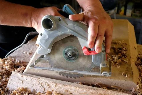 Hands with a tool on the background of a carpentry workshop. Stock Photos