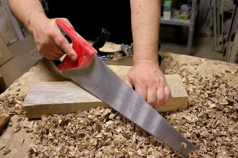Hands with a tool on the background of a carpentry workshop. Stock Photos