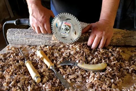Hands with a tool on the background of a carpentry workshop. Stock Photos