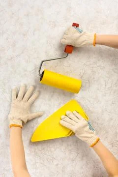 Hands with tools for wallpapering Stock Photos