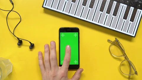Hands top view. Man using her smartphone with green screen in table , scrolling Stock Footage 130064204