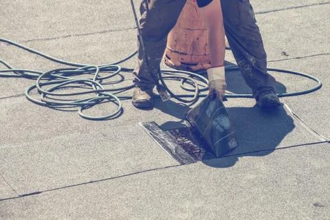 Hands with torch applied modified bitumen felt Stock Photos