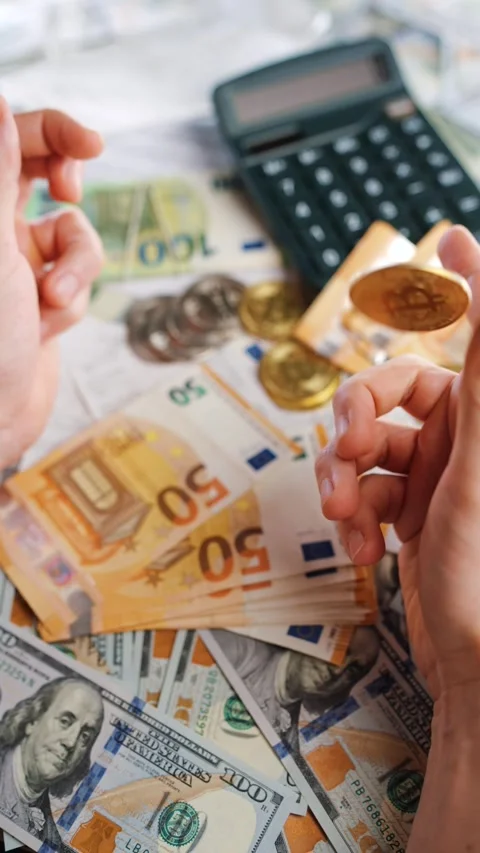 Hands toss and rotate BTC bitcoin against the dollars and euros Stock Footage 311869063