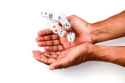 Hands Tossing White Dice with Red and Blue Dots Against a White Background Stock Photos