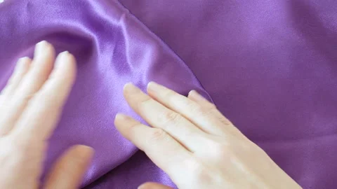 Hands touch violet silk fabric background with folds. Abstract texture  Stock Footage 126309803