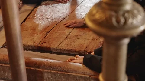 Hands touching and resting on the Stone of Anointing in Church of Holy Sepulchre Stock Footage 253105922