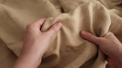 Hands touching soft beige linen fabric. Expensive fabric for luxury clothes. Stock Footage 317094231
