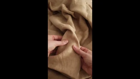 Hands touching soft beige linen fabric. Expensive fabric for luxury clothes. Stock Footage 317094336