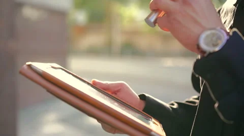 Hands touching tablet screen and smoking e-cigarette on the street Stock-Footage 64718087