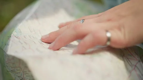 Hands trace detailed outdoor map, Quiet moment of route planning outdoors Stock Footage 331201460