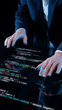 Hands on transparent digital surface with luminous programming code in Foto stock