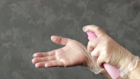 Hands in transparent gloves using antiseptic spray Stock Footage 150894397