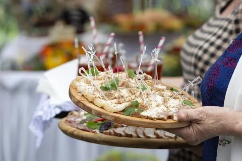 In the hands of a tray with meat snacks for a buffet table or tasting. Foto stock