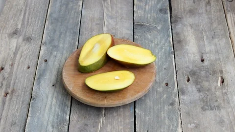 Hands tries to collect back sliced mango Stock Footage 129625633