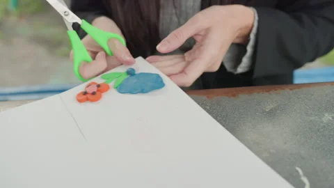 Hands trimming paper to assemble educational decorative poster. Focused on Stock Footage 333097425