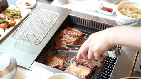 Hands turn meat over a glowing grill Stock Footage 340961017