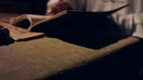 Hands Turning Pages of Ancient Book with Calligraphy on Desk Vídeos de archivo 334646612