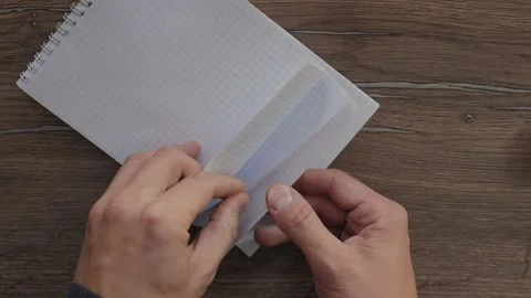 Hands turning pages in spiral notepad on wooden table Stock Footage 341364224