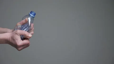 Hands twisting bottle crumpled plastic reduce concept. Crushed bottle water Stock Footage 181208123